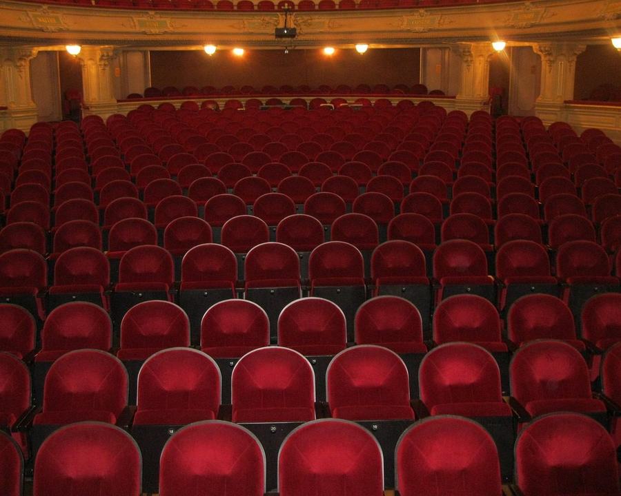 Puste czerwone fotele na widowni teatru