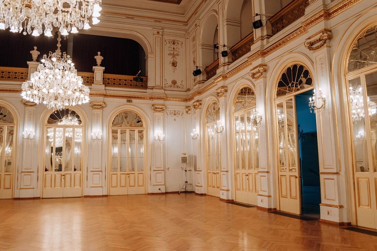 Foyer z kryształowymi żyrandolami i złoconymi zdobieniami